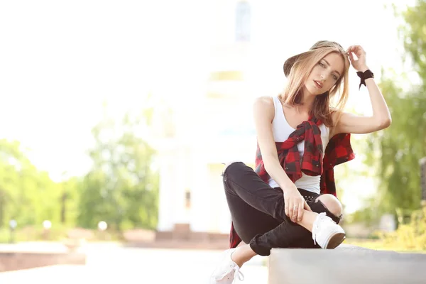 Mooie jonge vrouw zittend op een beteugelen buitenshuis — Stockfoto
