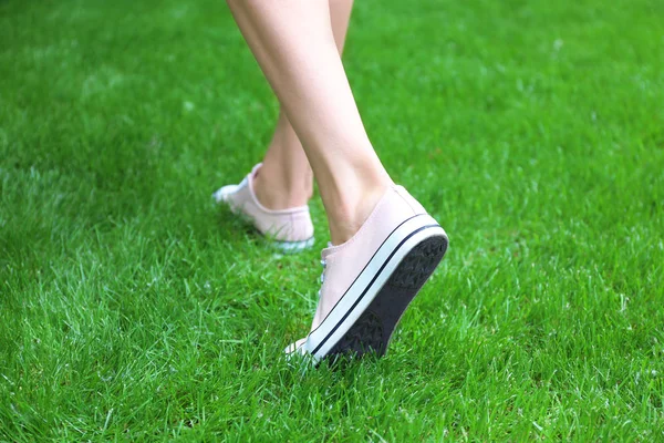 Patas femeninas en zapatillas rosas — Foto de Stock