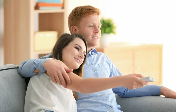 Молодая пара смотрит телевизор дома — стоковое фото