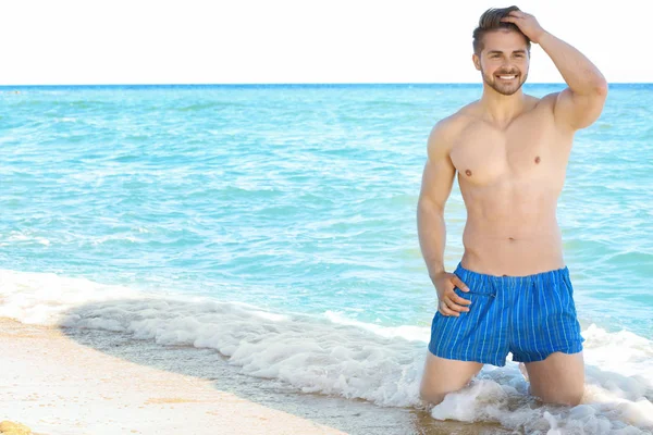 Yakışıklı genç adam sahilde