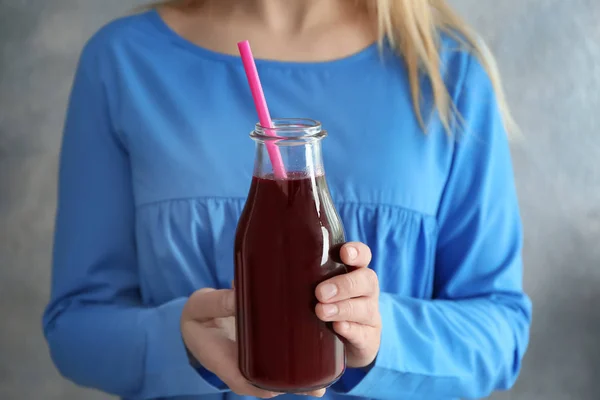 Young woman holding bottle of beet smoothie — Stock Photo, Image