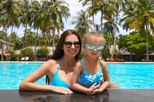 Vacker ung kvinna med dotter i poolen — Stockfoto