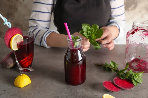 Mujer joven preparando batido de remolacha — Foto de Stock