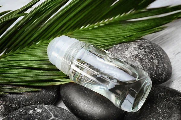 Desodorante sobre piedras y hojas — Foto de Stock