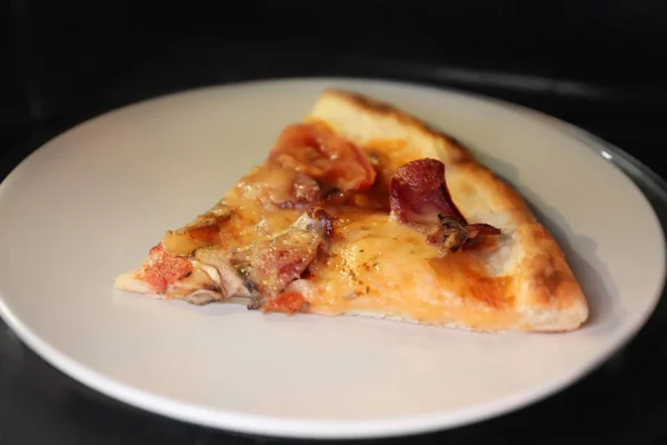 Plaat met plak van pizza in magnetron — Stockfoto