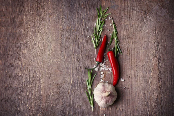 Composition with fresh rosemary, chili and garlic on wooden background — Stock Photo, Image