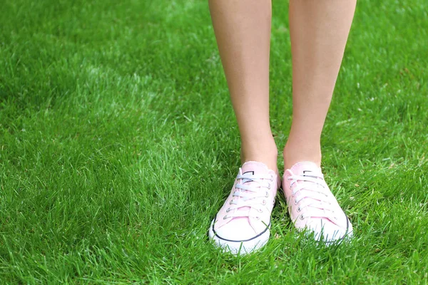 Pernas femininas em sapatilhas rosa — Fotografia de Stock
