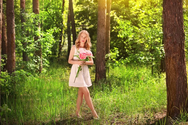 Jonge vrouw met boeket van pioenrozen — Stockfoto