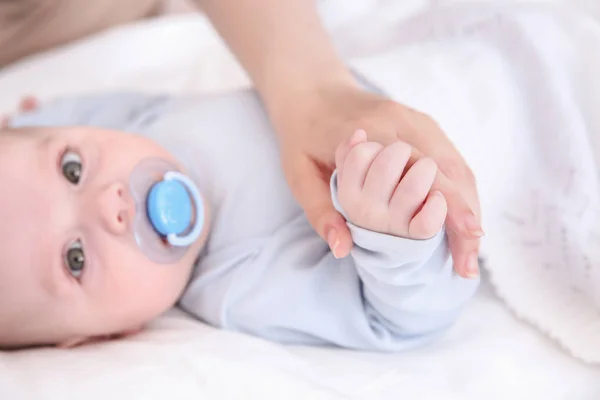 Mãe segurando mão de bebê bonito, close-up — Fotografia de Stock