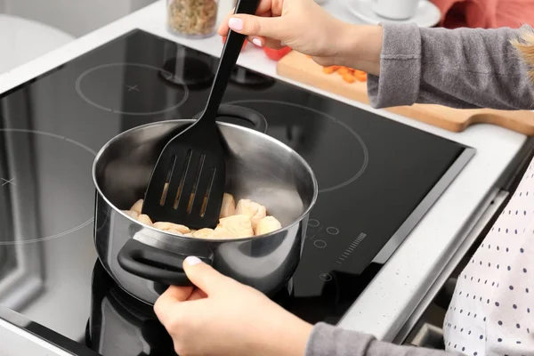 Woman cooking turkey chili on modern stove — Stock Photo, Image