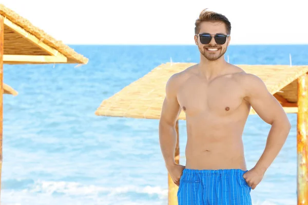 Bello giovane uomo sulla spiaggia — Foto Stock