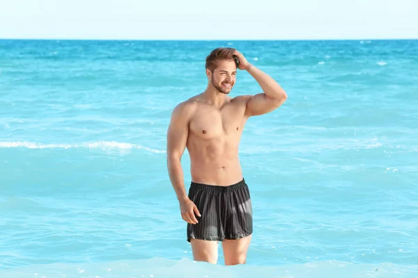 Hombre gordo divertido en un traje de baño con un círculo inflable en