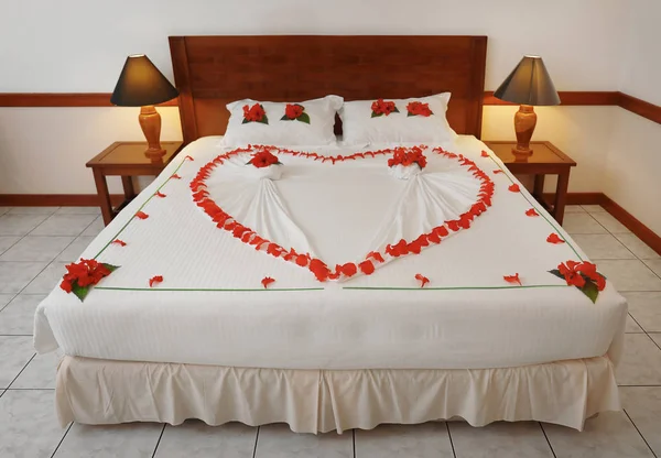 用鲜花做的心装饰的床 — 图库照片