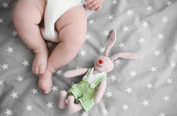 Lindo bebé con juguete acostado en la cama en casa — Foto de Stock