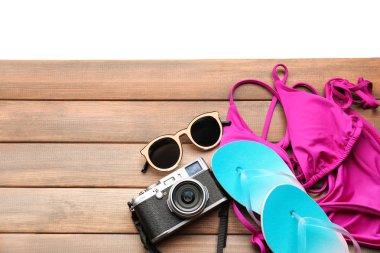 Kamera, Mayo, güneş gözlüğü ve ahşap tahta üzerinde parmak arası terlik ile kompozisyon. Tatil kavramı