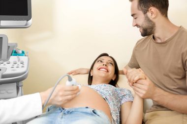 Klinikte ultrason geçiren genç hamile çift tarama