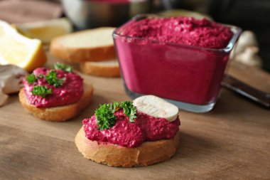 Kare cam kase lezzetli pancar humus ahşap tahta üzerinde sandviçle