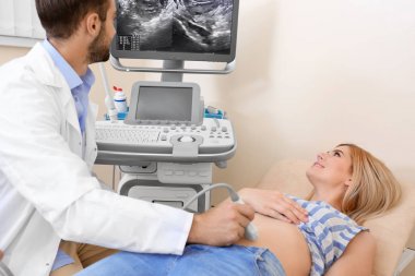 Klinikte ultrason taraması yaptıran genç bir kadın.