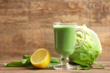 Ahşap arka plan üzerinde taze yeşil smoothie ile kompozisyon