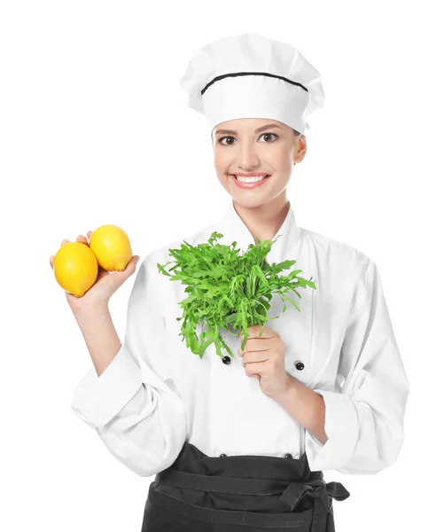 Young female chef with ruccola and lemons on white background — Stock Photo, Image