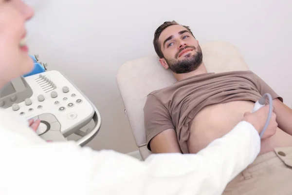 Young man undergoing ultrasound scan in clinic — Stock Photo, Image