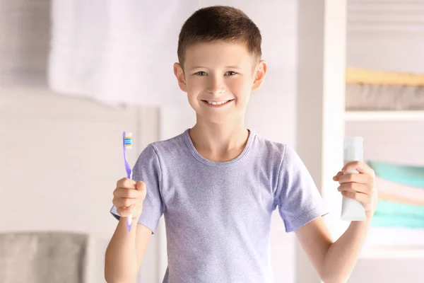 Ragazzino carino con spazzolino e pasta a casa. Pulizia dei denti concetto — Foto Stock