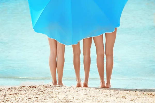 Vackra unga kvinnor med paraply resort till sjöss — Stockfoto