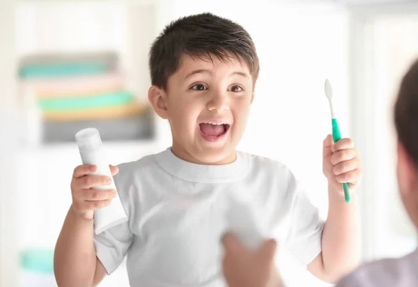 Milý chlapeček s zubní kartáček a pasta doma. Čištění zubů koncept — Stock fotografie