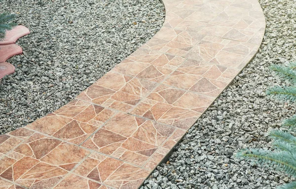 Pathway made from ceramic tiles with crushed stone in garden — Stock Photo, Image