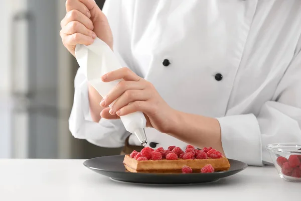 Vrouwelijke chef-kok versieren dessert in keuken, close-up — Stockfoto