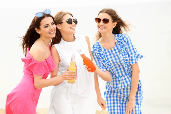 Jovens mulheres bonitas com bebidas alcoólicas no resort do mar — Fotografia de Stock