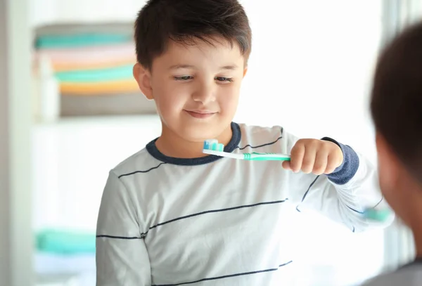 Bonito menino limpando os dentes em casa — Fotografia de Stock