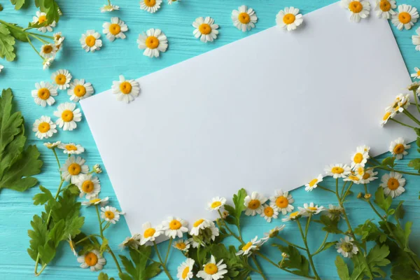 Pusty arkusz papieru z rumianku piękne kwiaty na podłoże drewniane — Zdjęcie stockowe