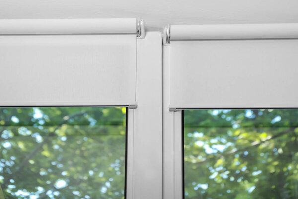 White roller blinds on plastic window