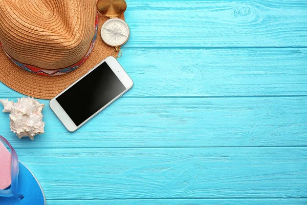 Telefon ve ahşap zemin üzerine şapka kompozisyonu. Tatil kavramı