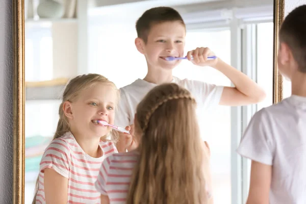Lindos niños pequeños limpiando dientes en casa —  Fotos de Stock