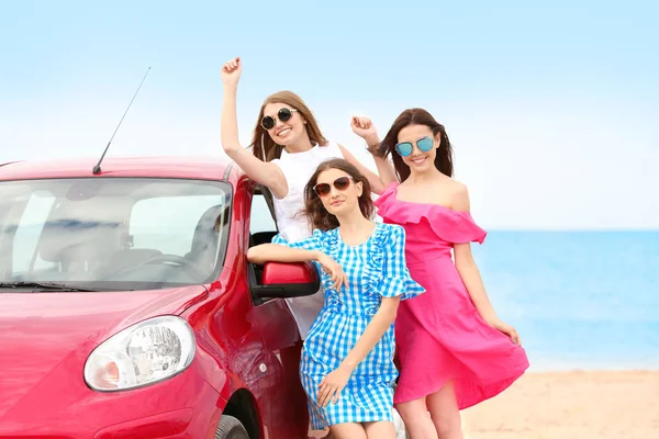 Belle giovani donne vicino auto in località balneare — Foto Stock
