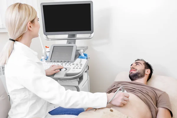 Young man undergoing ultrasound scan in clinic — Stock Photo, Image