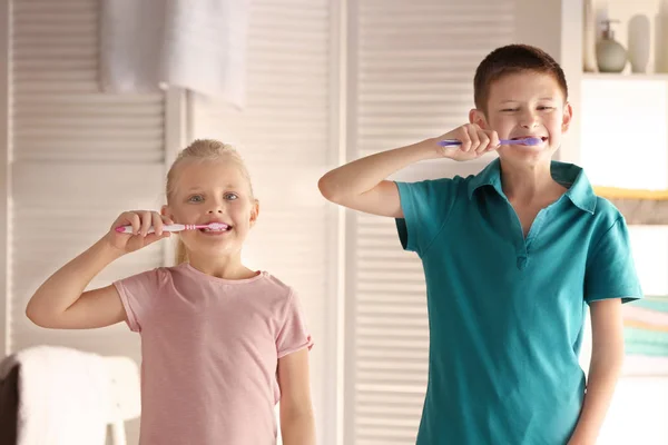 Милые маленькие дети чистят зубы дома — стоковое фото