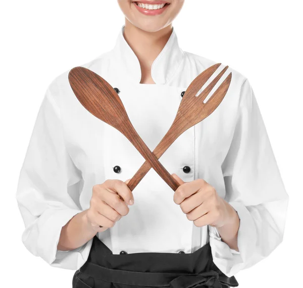Jonge vrouwelijke chef-kok met gebruiksvoorwerpen op witte achtergrond — Stockfoto