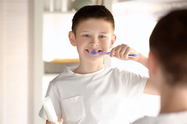 Cute little boy cleaning teeth at home