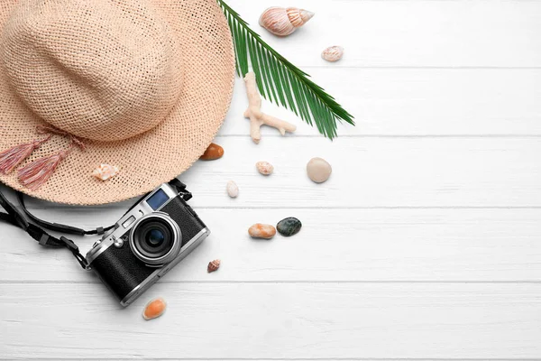 Şapka ve kamera üzerinde ahşap arka plan kompozisyonu. Tatil kavramı