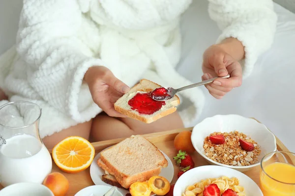 Joven hermosa mujer desayunando en la cama —  Fotos de Stock