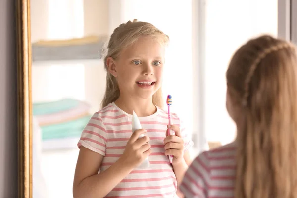 歯ブラシとペーストを自宅でかわいい女の子 クリーニング歯のコンセプト — ストック写真