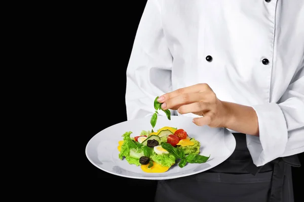 Junge Köchin hält Teller mit Salat — Stockfoto