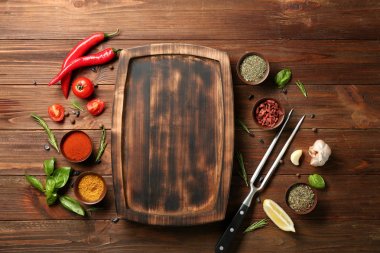 Ahşap plaka, baharatlar ve sebzeler masada kompozisyonu