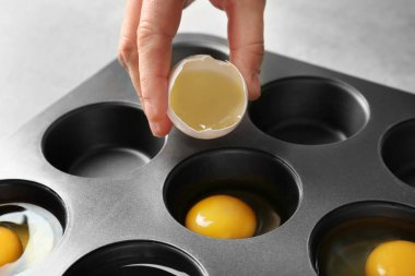 Çörek teneke, closeup içine yumurta çatlama kadın