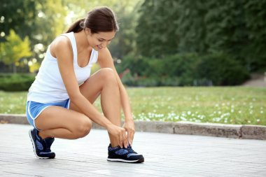 Sportif kadın ayakkabı bağcığı açık havada bağlama