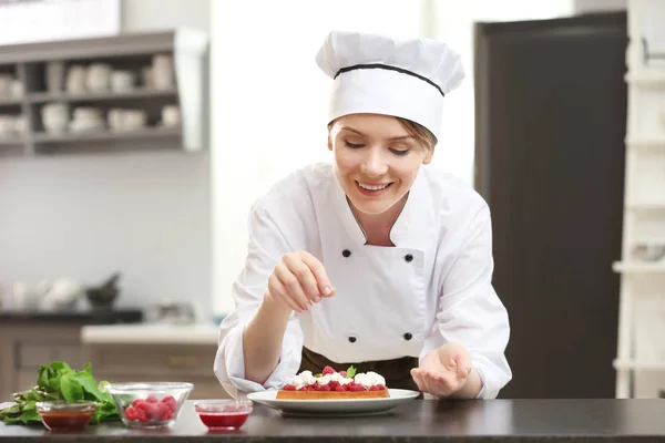Vrouwelijke chef-kok versieren dessert — Stockfoto