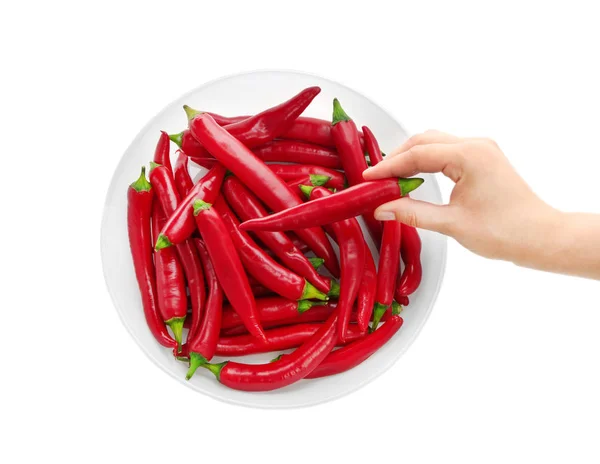 Woman's hand taking red chili pepper out of bowl isolated on white — Stock Photo, Image